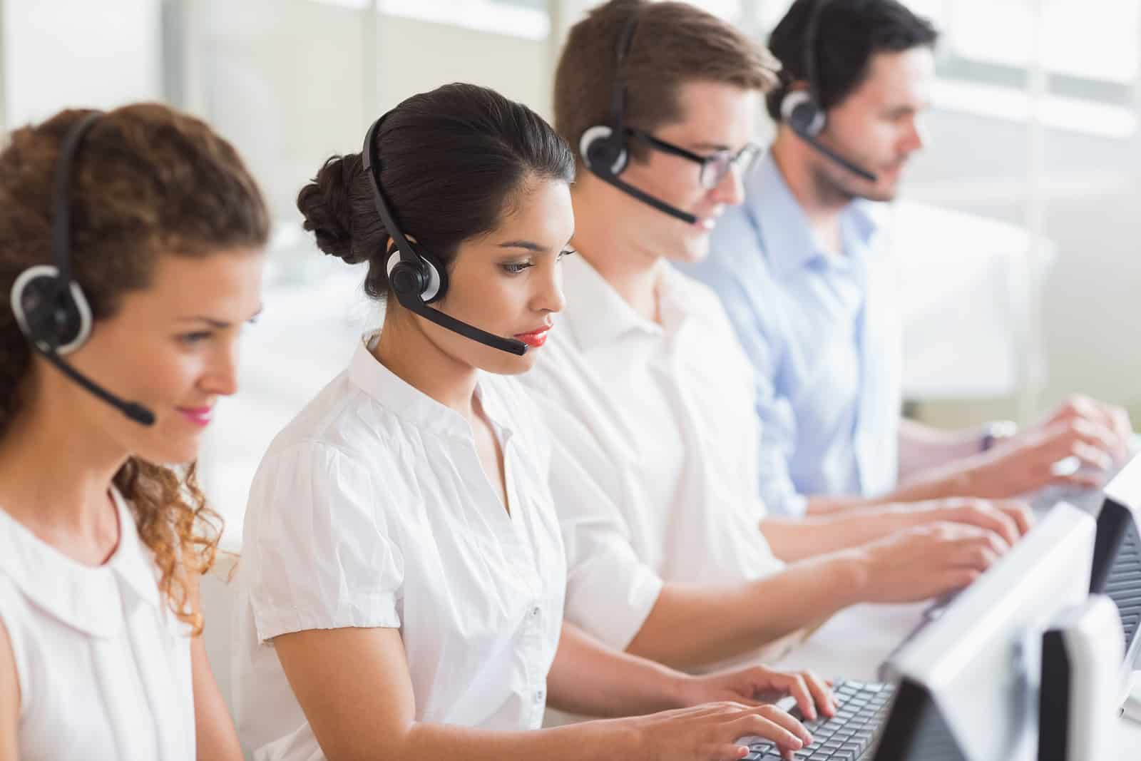 Customer service operators working at desk in office